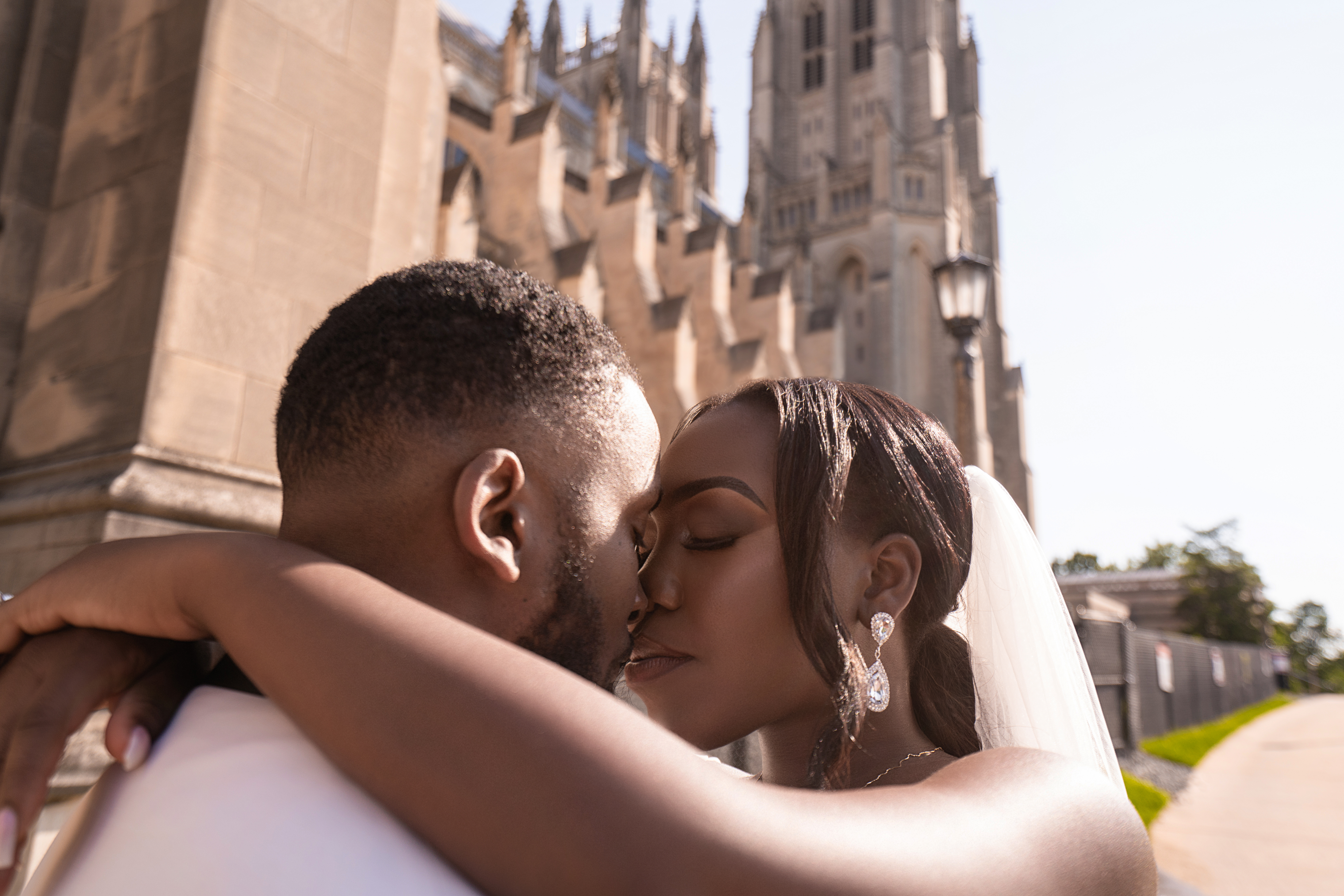 Black couple kissing in front of castle like infrastructure 